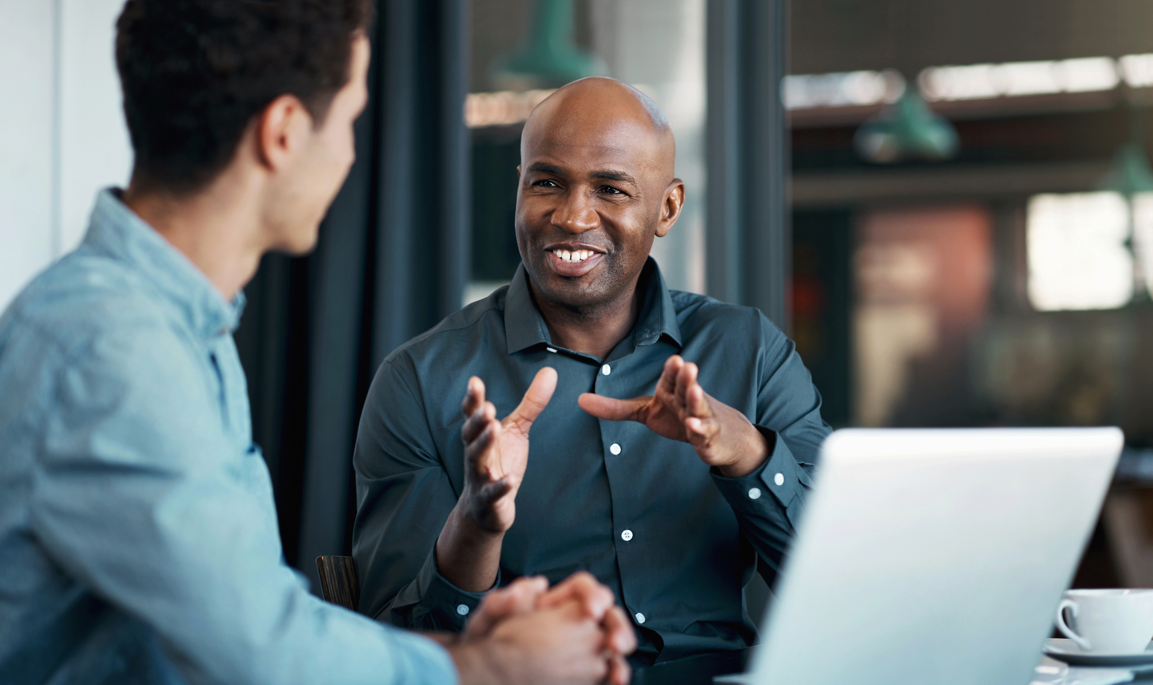 A manager talks with an employee in an office.